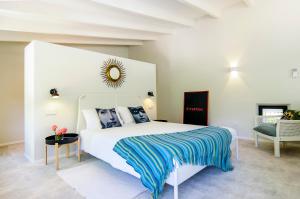 a bedroom with a white bed with a blue blanket at Hort Petit de Ternelles in Pollença +20 photos