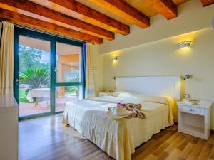 a bedroom with a bed and a sliding glass door at Villa Barbarina - Nature Resort with Pool & Restaurant - Alghero in Santa Maria la Palma