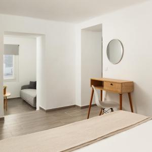 a room with a table and a mirror and a bed at DK Square in Andros