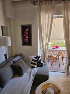 a living room with a couch and a large window at QUTE apartment in Hanioti