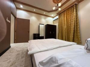 a bedroom with two beds and a window at ملاذ in Quai