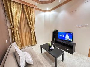 a living room with a couch and a tv at ملاذ in Quai