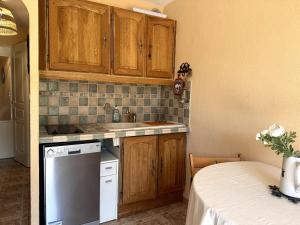 a kitchen with wooden cabinets and a white dishwasher at AL Cosy in Vars Ski & Nature in Vars