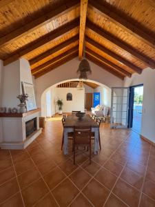 a large living room with a wooden ceiling and a table at Monte da Carrasqueira in Santiago do Cacém