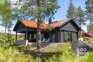 una baita di tronchi con un portico e un albero di The Lazy Moose a Tällberg