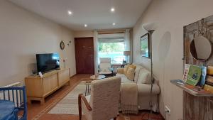 a living room with a couch and a tv at Casa Cortegada in Vilagarcia de Arousa
