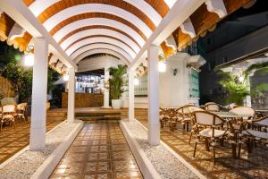 a patio with tables and chairs under a ceiling at Hotel Boutique Zahara in Zahara de los Atunes