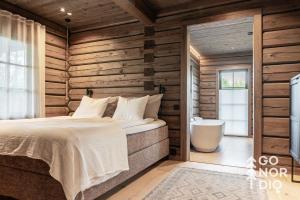una camera da letto con un letto e una vasca da bagno di The Lazy Moose a Tällberg