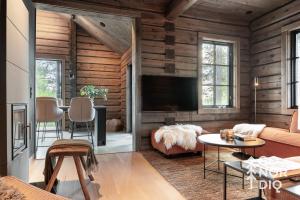 un soggiorno con pareti in legno e TV a schermo piatto di The Lazy Moose a Tällberg