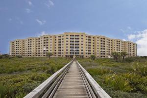 a building with a wooden walkway in front of a building at Surf Club I, 1405 in Marineland