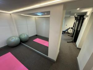 圣比斯Grindal Studio Apartments - Newly Opened Luxury Accommodation的一间带镜子的房间和一间带粉色垫子的健身房