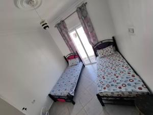 two beds in a room with a window at Martil 2 bedroom apartment in Martil