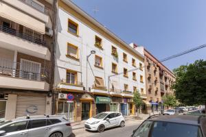 dos autos estacionados frente a un edificio en una calle en Charming 2 bedroom Apartment at Virgen de Begoña, en Sevilla