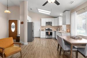 eine Küche mit weißen Schränken und einem Tisch und Stühlen in der Unterkunft Modern Southwest Escape 2 Master Bedrooms in Bakersfield