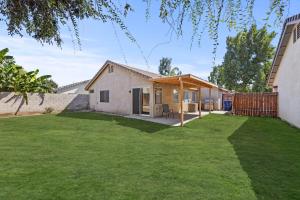 ein Haus mit einem großen Garten mit Gras in der Unterkunft Modern Southwest Escape 2 Master Bedrooms in Bakersfield