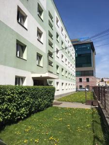 a building with a grass yard in front of a building at ZipStay Inn in Cluj-Napoca