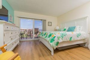 a bedroom with a bed and a balcony at St Augustine Beach Tennis 405 New in Saint Augustine +35 photos