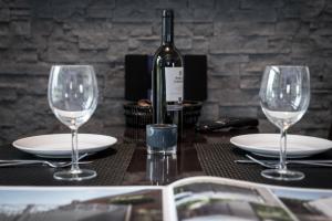 a table with two wine glasses and a bottle of wine at Triumph Inn Pension in Rangsdorf +19 photos