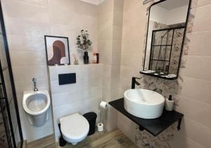 a bathroom with a sink and a toilet and a urinal at Alexandru Apartment in Bucharest +6 photos