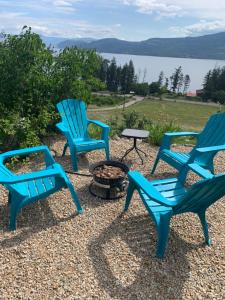 a group of three chairs and a fire pit at Panoramic Acres B & B - Lake & Mountain Views in Vernon
