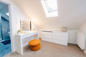 a bathroom with a vanity with a mirror and a stool at Spacious 7 Bedroom 5 Bathroom Mansion with Parking in Cardiff +62 photos