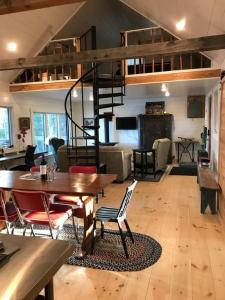 a living room with a dining table and a loft at Lakefront Cottage by Country House Escapes in Lincolnville