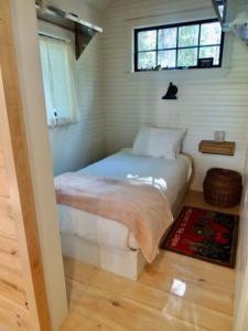a bedroom with a bed in a room with a window at Lakefront Cottage by Country House Escapes in Lincolnville