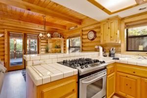 a kitchen with wooden walls and a stove top oven at Knotty and nice #177 in Big Bear Lake