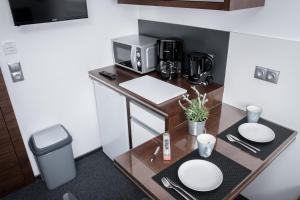 a small kitchen with a table with a coffee maker at Triumph Inn Pension in Rangsdorf