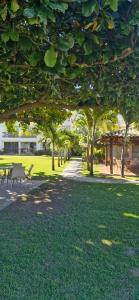 a park with a bunch of trees and picnic tables at Apartamento no Paraíso dos Corais com Vista Mar in Camacari