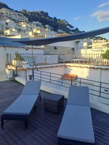 2 panche su un balcone con vista sulla città di Casa La stellina a Capri
