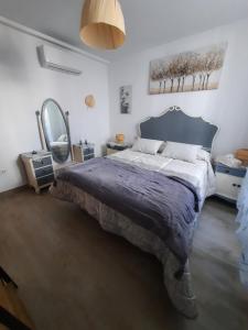 une chambre avec un grand lit et un grand miroir dans l'établissement Casa El Molino de Melegis - Lecrin Valley, à Melegis