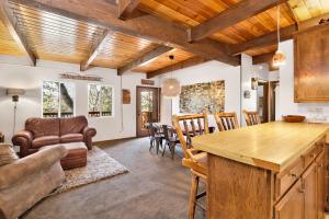 eine Küche und ein Wohnzimmer mit Tisch und Stühlen in der Unterkunft Chipmunk treehouse #1983 in Big Bear Lake