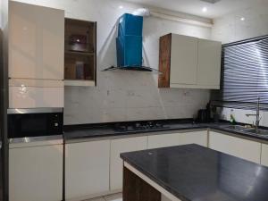 a kitchen with white cabinets and a black counter top at Vienna manilla court in Lagos +3 photos