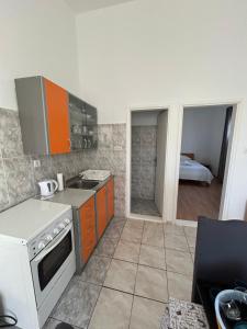 a kitchen with orange cabinets and a stove top oven at Apartmani Paklenica in Razvala