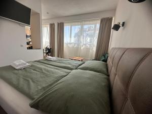 a bedroom with a large green bed and a window at bookVienna "Paula" Apartments in Vienna