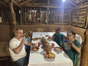 a group of people sitting at a table eating food at Araliya Self Cooking Resort Dambulla in Dambulla