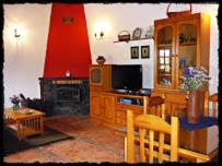 een woonkamer met een televisie en een tafel en stoelen bij Casa Rural Amasín in Valverde