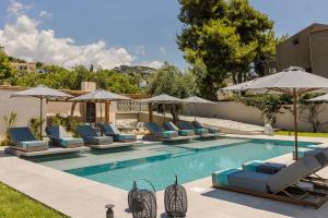 a swimming pool with lounge chairs and umbrellas at MARILIA VILLAS LASSI in Lassi