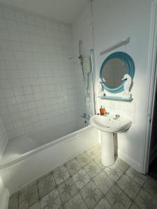 a bathroom with a sink and a mirror and a tub at Beautiful Central Brighton l Sea View I Spacious Studio Flat I Sleep 2-3 Guests in Brighton & Hove +8 photos