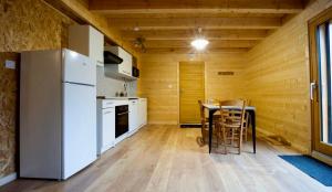 une cuisine avec un réfrigérateur blanc et une table dans l'établissement Le Nine CHALET COSY - NATURE, LAC, MONTAGNES & GOLF, à Giez