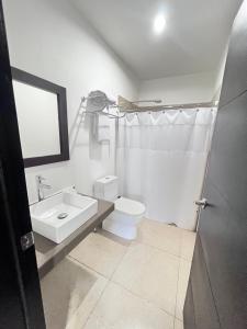 a white bathroom with a sink and a toilet at Room 7 Ciudad Jardin in San Miguel +5 photos