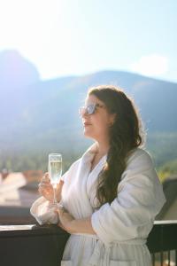 a woman holding a glass of white wine at Kananaskis Mountain Lodge, Autograph Collection in Kananaskis Village