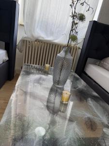 un tavolo di vetro con un vaso e due candele sopra di Urban Nest Prime 3BR with Spacious Hall & Kitchen apartment a Kelkheim