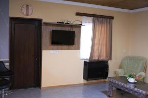 a living room with a tv on the wall and a table at Sun-Kissed House in Kutaisi