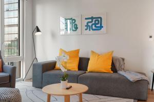 sala de estar con sofá gris y almohadas amarillas en Sophisticated 4BR Suite - Modern and Luxurious, en Chicago