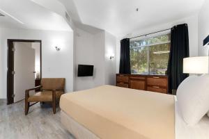a bedroom with a bed and a chair and a window at Metro Extended Stays , Chandler - Cozy 2 Beds in Chandler