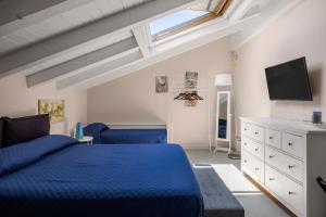 a bedroom with a blue bed and a flat screen tv at Luxury Panoramic Loft with heated saltwater pool and parking near Taormina, Catania, the Sea and Mount Etna by SicilianRelaxingHomes in Giarre