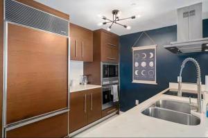 a kitchen with wooden cabinets and a sink and a refrigerator at Modern Icon Brickell Condo by Palermo Home Miami in Miami