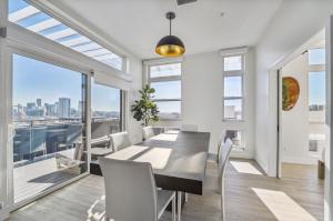 a dining room with a table and chairs and a large window at The Penthouse | Espadin LoHi in Denver